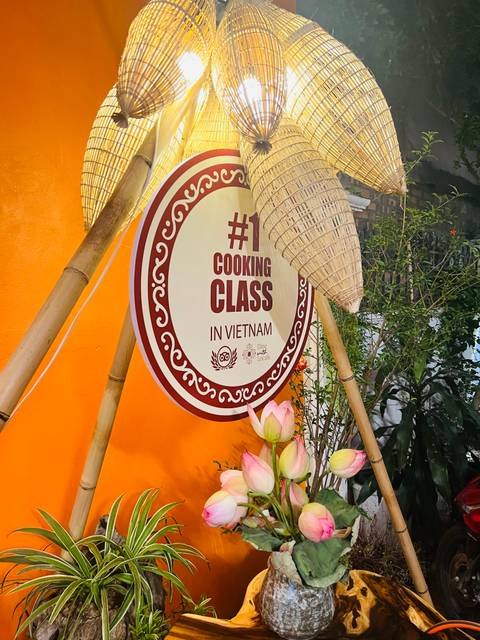 Sign advertising a cooking class in Vietnam with decorative elements.