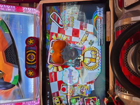 Arcade game display with avatar and Japanese text.