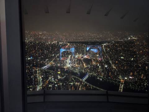       Night view of a city skyline with illuminated buildings.
  