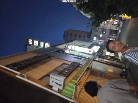 Blurry street scene with people and brightly lit signage.