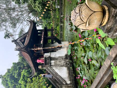      Traditional Vietnamese temple on stilts above a pond with lily pads.
  