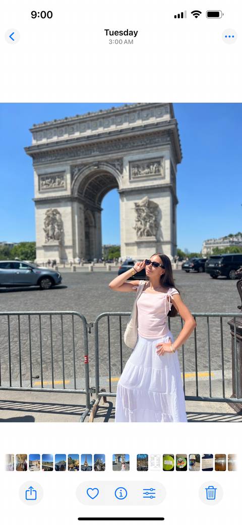 Woman posing in front of the Arc de Triomphe.
