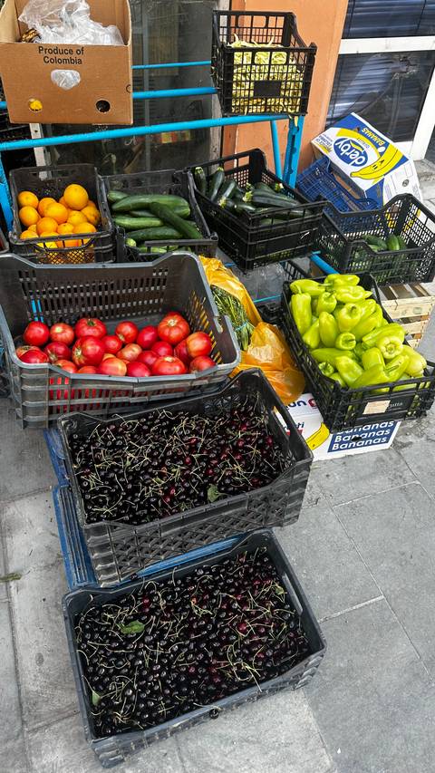       Crates of fresh produce including tomatoes, cherries, and peppers on display.
  