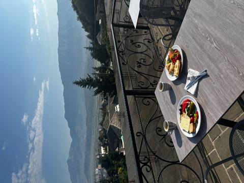       Breakfast setup on a terrace with a mountain view in the background.
  