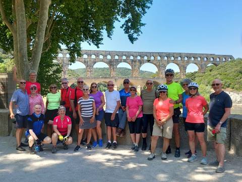 Group of cyclists posing at the Pont du Gard.