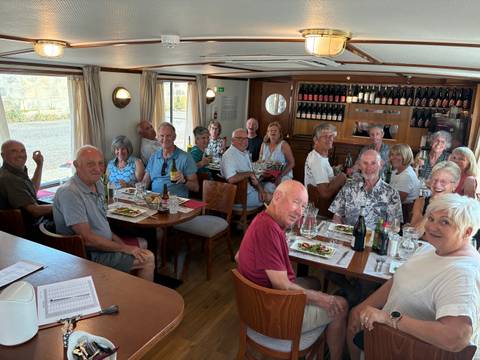 Group of people dining on a boat.