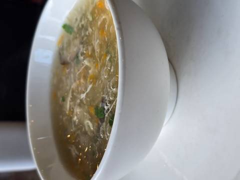      Close-up of a steaming hot bowl of soup on a white table.
  