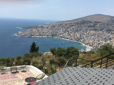 Aerial view of a coastal city with a large bay and mountains in the background.