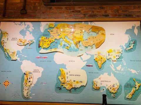 World map on a brick wall, showcasing various continents.