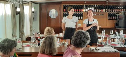 Women giving a presentation in a restaurant setting.