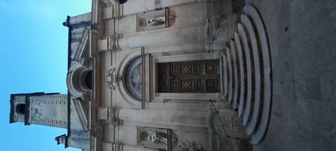 Stone building with intricate architecture and steps.