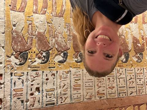 Person with ancient Egyptian wall art.