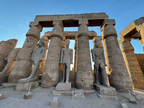 Columned ruins with statues of pharaohs.