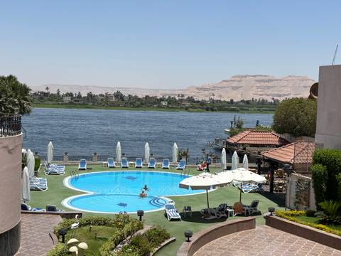 Riverside hotel pool with desert backdrop.