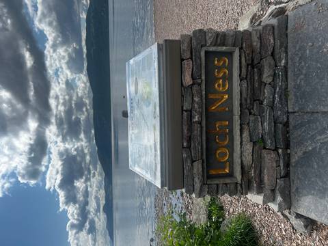 Loch Ness sign with water and hills in the background.