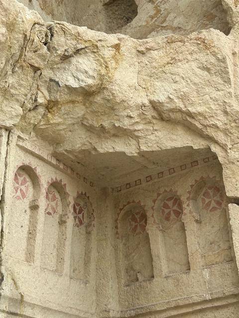       Rock sculptures with geometric patterns inside a cave.
  