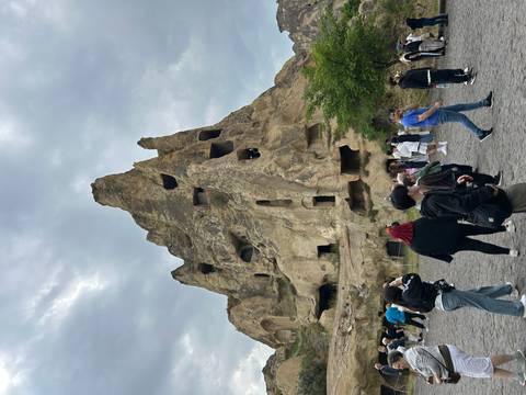       People exploring a large rock formation in Cappadocia.
  
