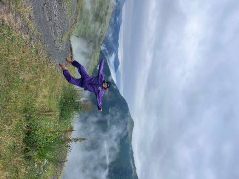       Person in mid-air jump with misty mountains in the background.
  