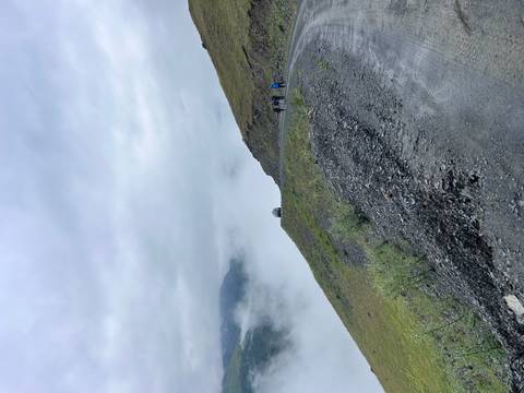       People walking on a misty mountain road.
  