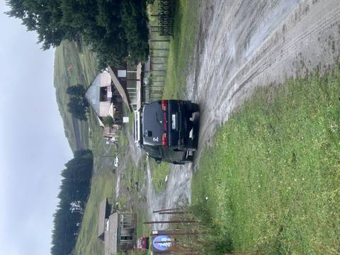 Rural road with van driving through a green landscape.