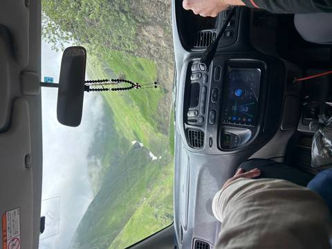      Interior car view with a scenic road ahead.
  