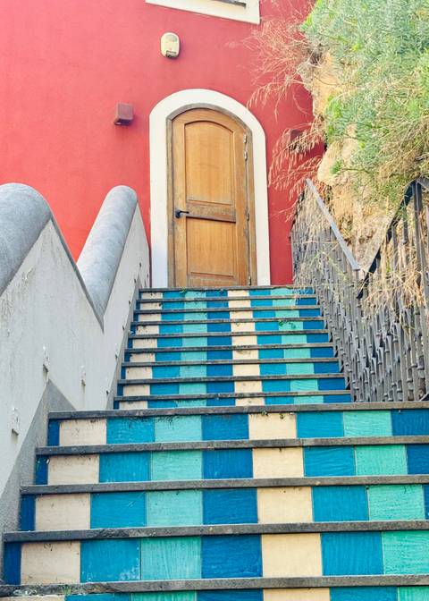 Colorful tiled stairs leading to a door.