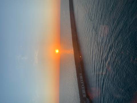 Sunset over the ocean seen from a distance.