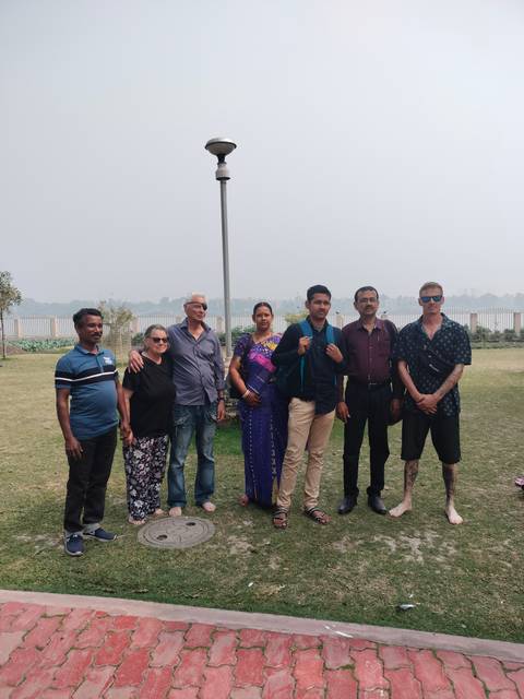Group of people posing in a park setting.