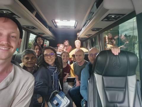 Group of people sitting inside a tour bus.