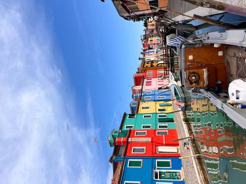 Boat on a canal with brightly colored houses along the water.