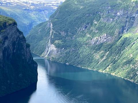       Deep fjord surrounded by steep green mountains.
  
