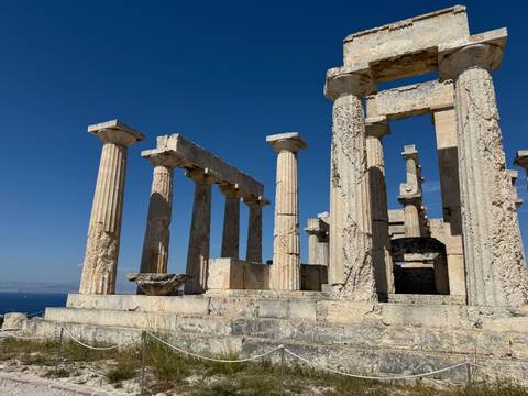       Ancient Greek temple ruins with a blue sky.
  