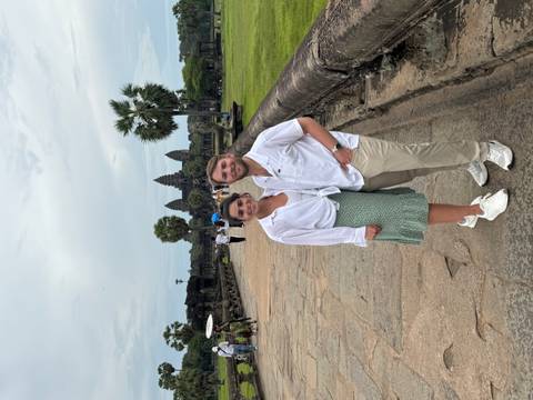 Couple standing in front of an ancient temple complex.