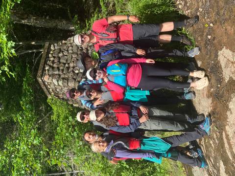       Group of people in hiking gear posing outdoors.
  
