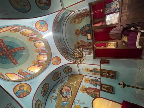       Interior of an ornate church with painted ceilings.
  