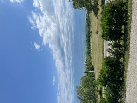 Scenic countryside with mountains under a cloudy sky.