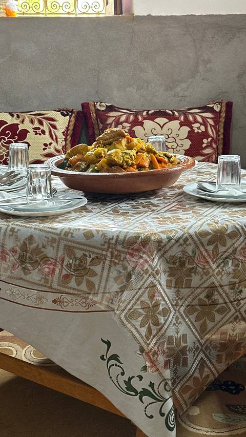       A plate of food on a table with several plates and glasses around it.
  