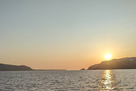 Sunset view over the sea with distant landforms.