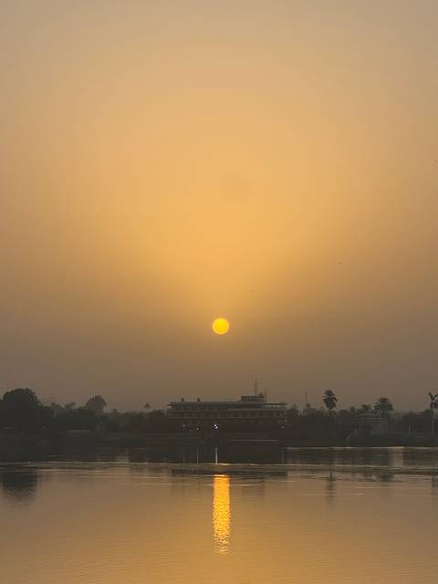       Hazy sunset with sun over city rooftops.
  