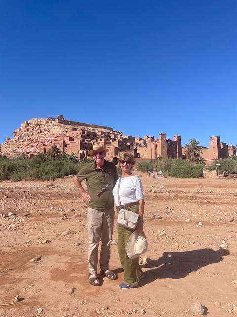       Couple posing in front of a historic sandstone fortress.
  