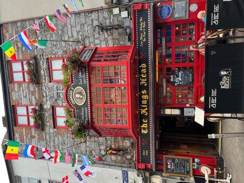 Front of The King's Head pub with red windows and decorations.