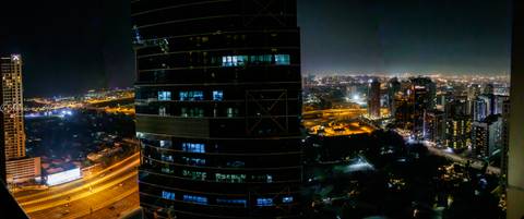 City skyline at night with illuminated buildings.
