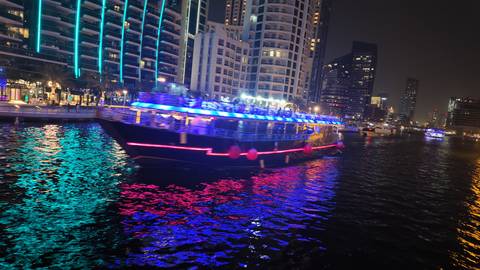 Boat illuminated with bright lights on the water at night.