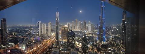 Expansive night view of a city with illuminated skyscrapers.