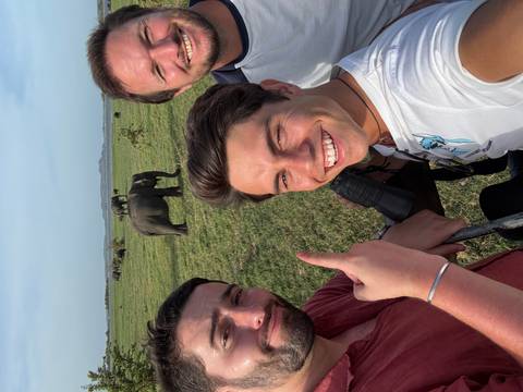       Group of friends taking a selfie with elephants.
  