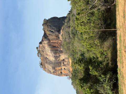       Prominent rock formation with lush surroundings.
  