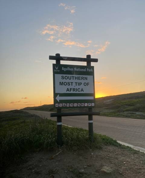       Sign for Agulhas National Park at sunset.
  