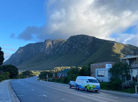       Mountain view with buildings and a road.
  