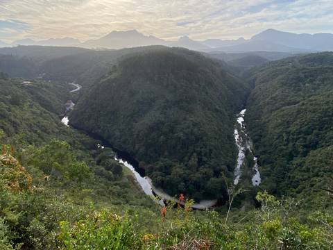       Aerial view of green hills and winding river.
  
