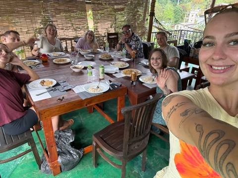 Group of people having a meal around a table.